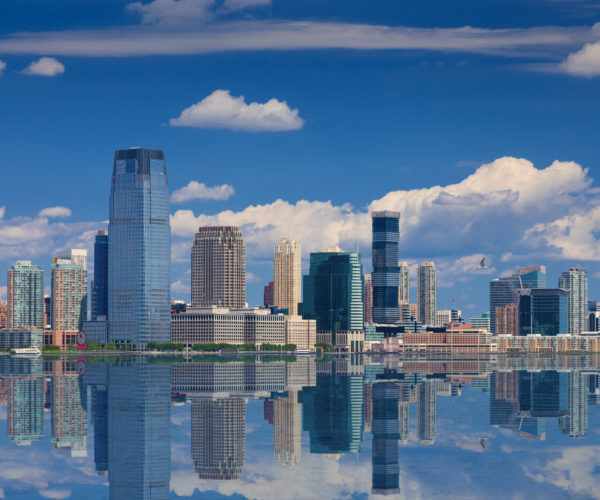 Jersey City Skyline with Goldman Sachs Tower Reflected in Water of Hudson River, New York, USA.